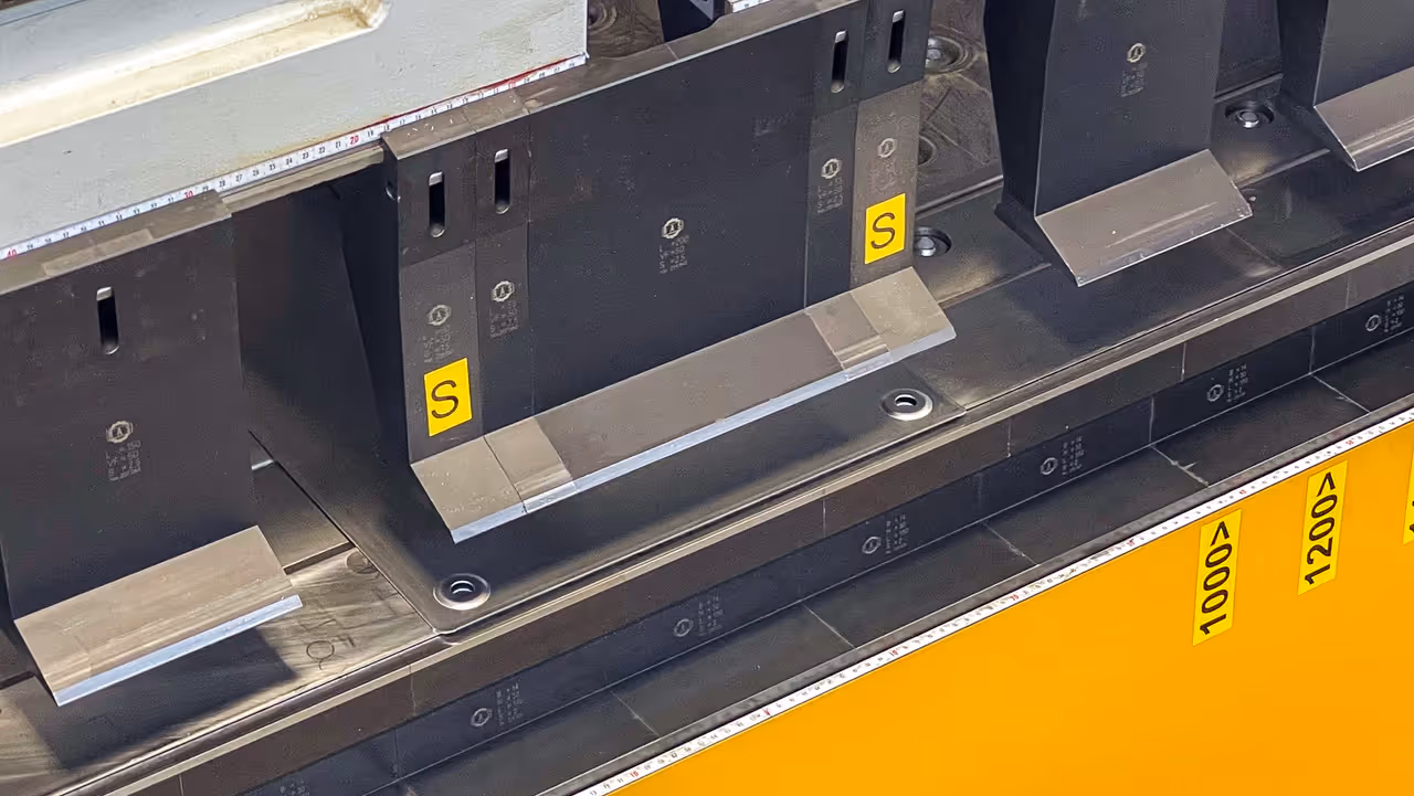 Detail segmentovaných nástrojů upnutých ve stroji podél měřicí stupnice se značkami poloh